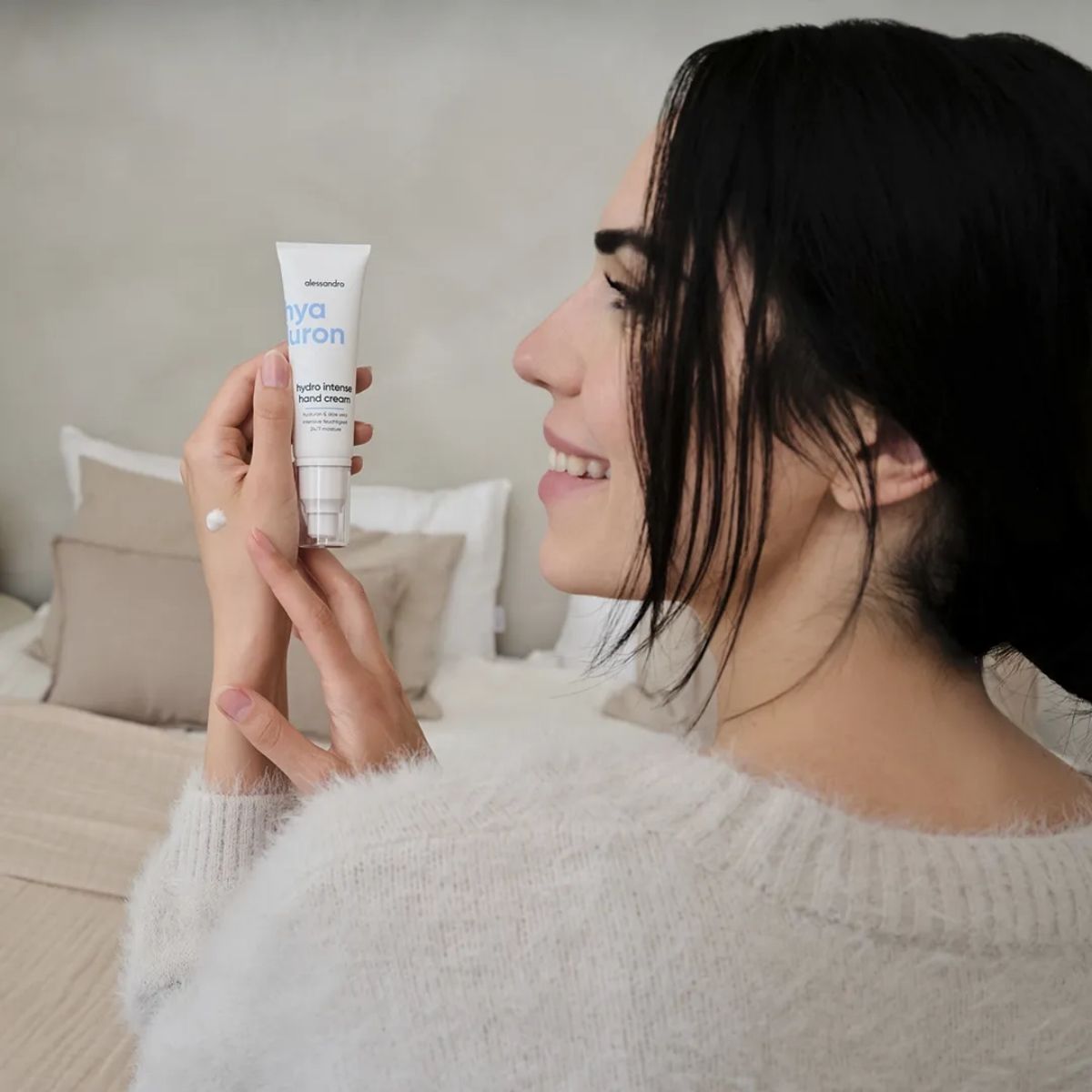 Жена държи крем за ръце Alessandro Hyaluron Hydro Intense с нанесено количество върху ръката